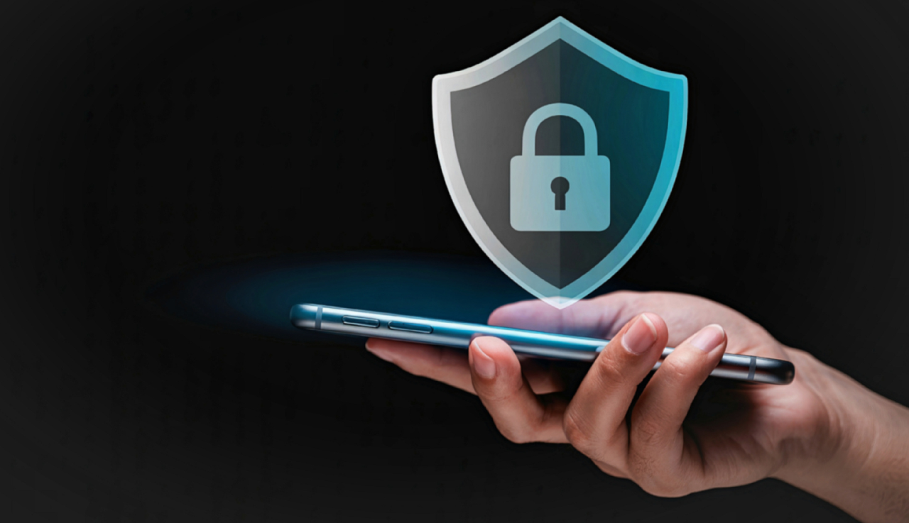 A person holds a phone upright and a padlock graphic sits over it.