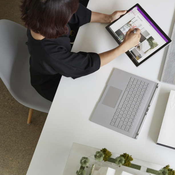 Overhead image of a lady using a tablet at her desk.