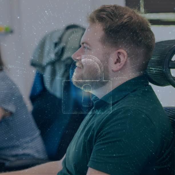 Millgate Team member sitting at his desk looking at his screen. A graphic of a padlock is overlayed.