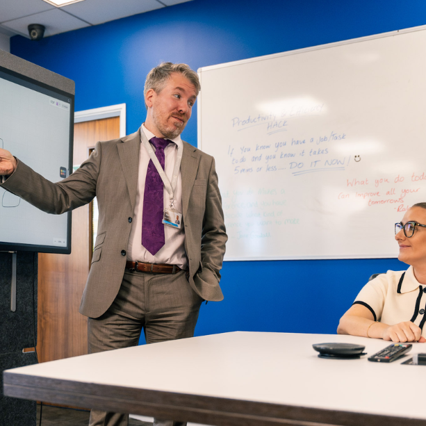 Male team member demonstrating cloud services to another team member.