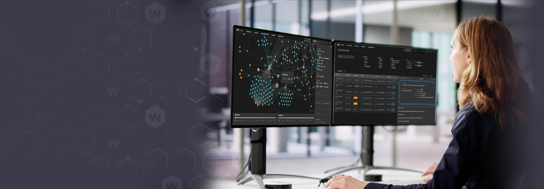 A woman is sitting at a desk facing two monitor screens as she works.