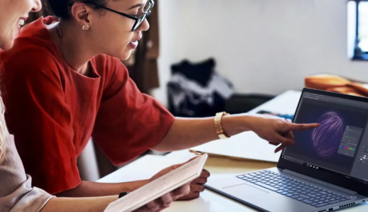 Woman points to laptop screen.