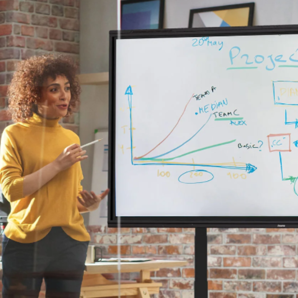 A woman stands before an iiyama board holding a pen.