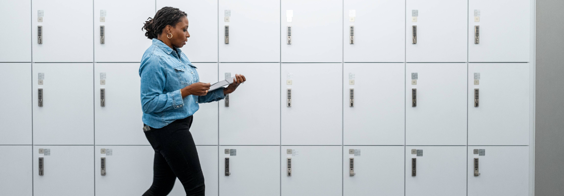 Woman walking in front of lockers.
