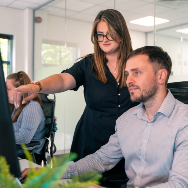 Two colleagues reviewing call analytics on a computer screen for Microsoft Teams Voice