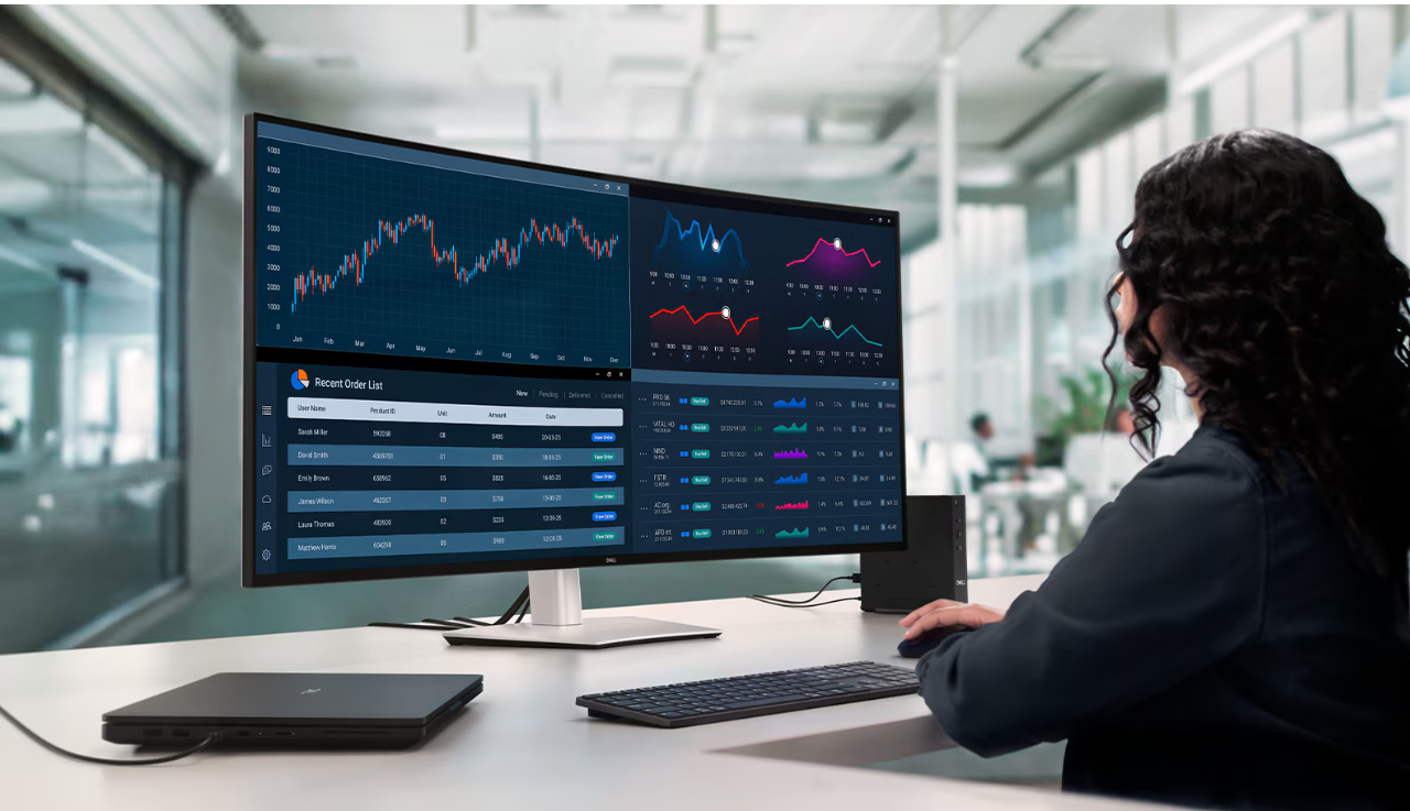 A worker is facing their Dell desktop screen at their desk, facing away from the camera.